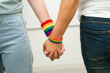 Gökkuşağı bilekliği takan Asyalı LGBT çifti..