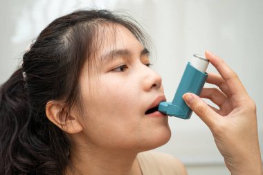 Astım ve kronik obstrüktif akciğer hastalığı COPD, ölçülü doz solunum cihazı kullanan Asyalı kadın..