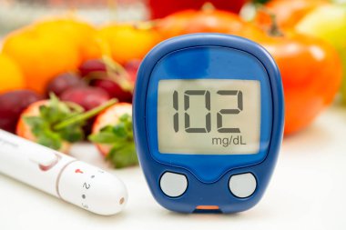 Asya 'da el ele tutuşan dijital glikoz monitörü sebze ve meyveli sağlıklı gıda ölçümü.
