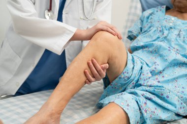 Hastanede, Asyalı yaşlı kadın diz protezi ameliyatını kontrol eden bir doktor..