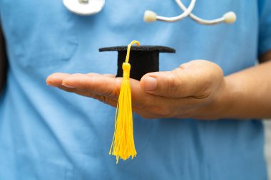 Asyalı doktor eğitimi, hastane koğuşunda mezuniyet şapkasıyla, zeki zeki dahi eğitim tıbbıyla öğreniyor..