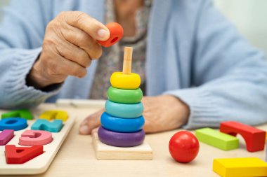 Alzheimer Hastalığı AD, bunama geçiren Asyalı yaşlı kadın hasta pratik motor beceri rehabilitasyonu öğreniyor.