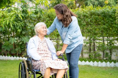 Bakıcı yardım ve bakım Asyalı yaşlı kadın hasta hemşire hastanesi koğuşunda tekerlekli sandalyede oturuyor, sağlıklı ve güçlü..