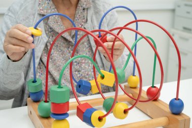 Asyalı yaşlı bir kadın, geliştirme oyunu oynuyor..