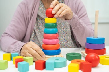 Alzheimer Hastalığı AD, bunama geçiren Asyalı yaşlı kadın hasta pratik motor beceri rehabilitasyonu öğreniyor.