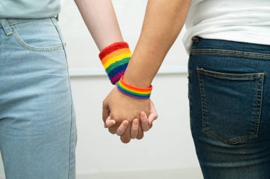 Gökkuşağı bilekliği takan Asyalı LGBT çifti..
