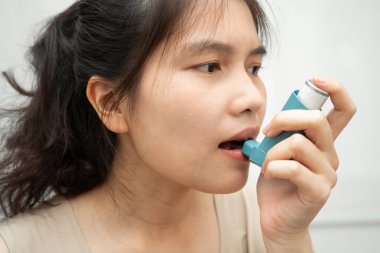 Astım ve kronik obstrüktif akciğer hastalığı COPD, ölçülü doz solunum cihazı kullanan Asyalı kadın..