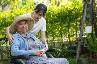 Bakıcı yardım ve bakım Asyalı yaşlı kadın hasta hemşire hastanesi koğuşunda tekerlekli sandalyede oturuyor, sağlıklı ve güçlü..