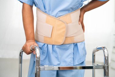 Ortopedik bel kemiği için sırt ağrısı destek kemeri takan Asyalı bir hasta..