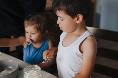 İki çocuğun, ev yapımı kek hazırlarken mutfak tartısını malzemelere göre ayarlarken yakın plan görüntüsü. Yemek konsepti. Aile aktivitesi konsepti. İnsanları sev