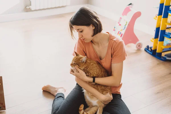 여자가 여름에 바닥에서 복슬복슬 고양이를 잡니다 관심을 나타내는 개념이다 긍정적 — 스톡 사진