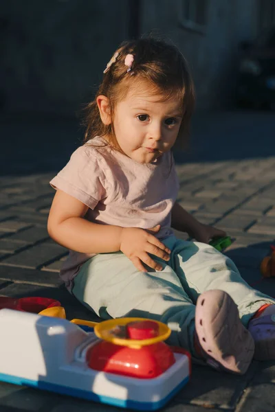 장난감 주방에서 즐겁게 소녀가 뜰에서 때마다앉아 있었다 아이들을 장난감 유치원 — 스톡 사진