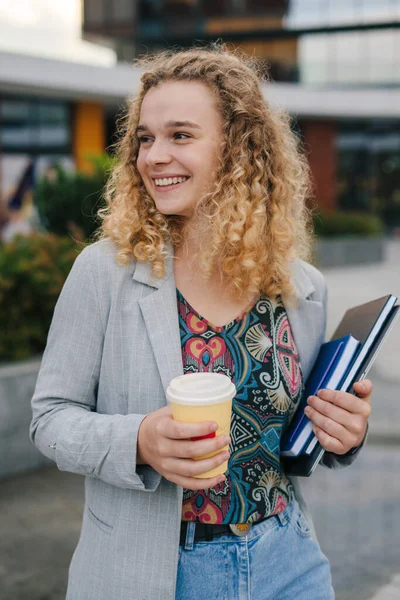 Portret Pięknej Studentki Kręconymi Włosami Pijącej Kawę Trzymającej Laptopa Notatniki — Zdjęcie stockowe