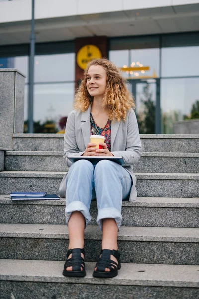 Όμορφη Νεαρή Φοιτήτρια Κάθεται Στις Σκάλες Πίνοντας Καφέ Ενώ Κάνει — Φωτογραφία Αρχείου
