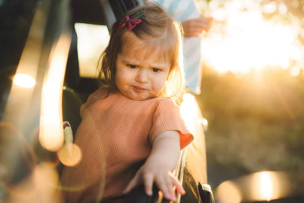 stock image Adorable caucasian baby girl looking from open car window on a sunny day. Road trip. Summer vacation. Happy family, childhood. Carefree childhood. Travel trip