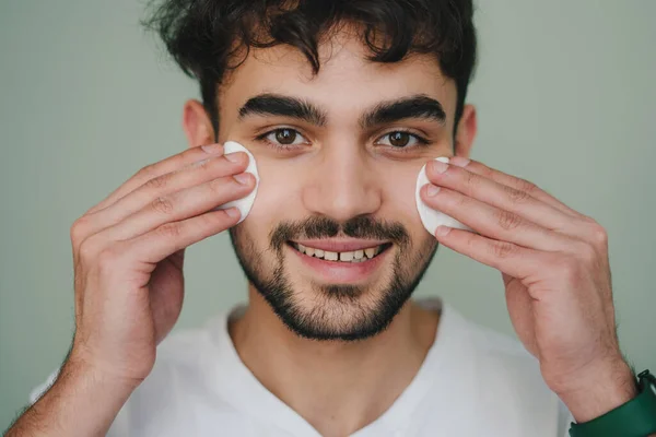 Όμορφος Άνδρας Καθαρίζει Πρόσωπο Δέρμα Βαμβάκι Μαξιλάρια Πάνω Από Πράσινο — Φωτογραφία Αρχείου