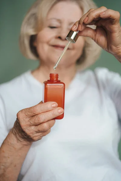 stock image Close-up view of elderly woman with dropper to apply serum to face. Therapy treatment, beauty skin care. Beauty woman face skin care.