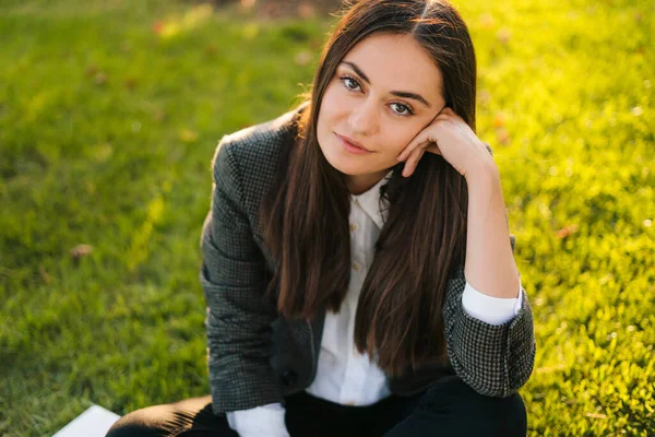 stock image Brunette haired businesswoman in stylish office clothes relaxing in park after work. Summer time. Green nature. Happy lifestyle.