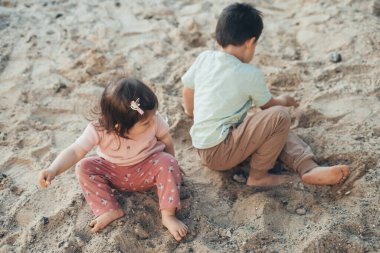 Kumda oynayan tatlı küçük çocuklar, kır bahçesinde doğanın tadını çıkarıyorlar. Açık hava aktivitesi. Çocuklar için açık hava yaratıcı aktiviteler