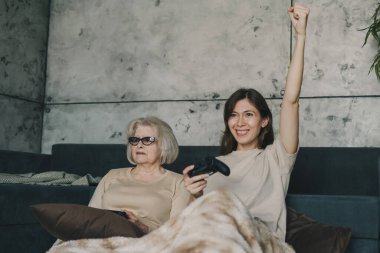 Mutlu gülümseyen yetişkin kız ve yaşlı anne evde oyun kağıtlarını kullanarak oyun oynuyorlar. Eğlence anlayışı, aile bağları ve boş zaman aktiviteleri. Çünkü...