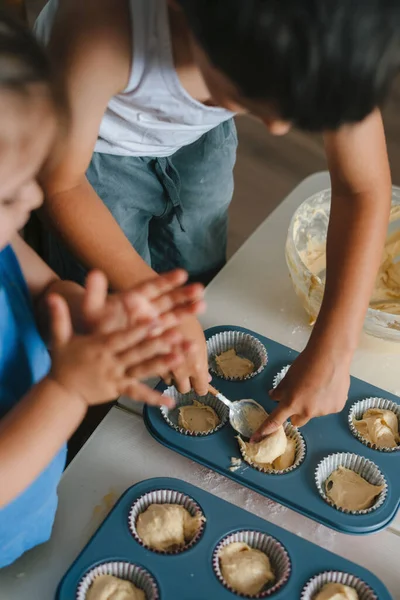 小孩在家里厨房里把自制的新鲜生面团倒入烘焙形式中烘焙烘焙烘焙烘焙蛋糕 用葡萄干做松饼 自制的 — 图库照片