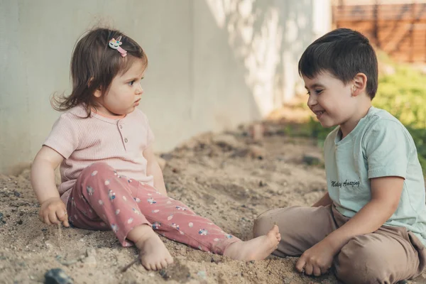 Seitenansicht Von Zwei Kindern Die Auf Sandigem Boden Sitzen Und — Stockfoto