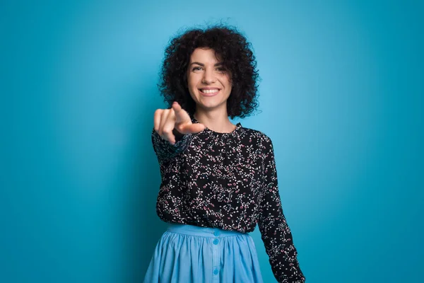 Kręcone Włosy Kobieta Shirt Wskazując Aparat Zębami Uśmiech Odizolowany Niebieskim — Zdjęcie stockowe