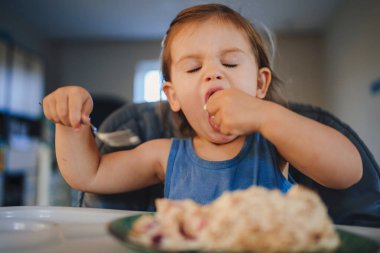 Küçük şirin bebek elleriyle, sağlığıyla ve beslenme yiyeceğiyle kendi kendine yemek yiyor. Sağlıklı yiyecekler. Sağlıklı beslenme.