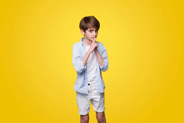 A frightened boy making emotion expression isolated over yellow background white. Loneliness, stress and fear.