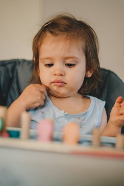 8 aylık bebek ahşap harflerle ve sayılarla oynuyor. Mutlu anne ve bebek evde vakit geçiriyor. Okul eğitimi. Mutlu bir yaşam tarzı. İnsan yaşam tarzı