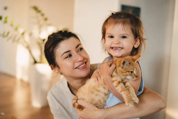 Portrait of a happy family with a cat, looking at camera and smiling. Family home leisure. Happy family.
