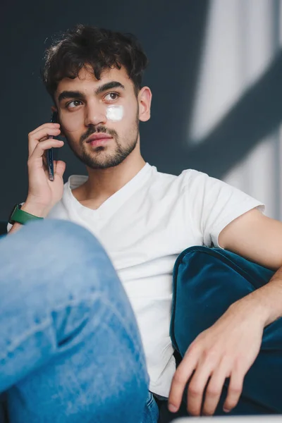 Ung Kaukasisk Man Sitter Soffan Hemma Och Pratar Smarttelefon Vardagsrummet — Stockfoto