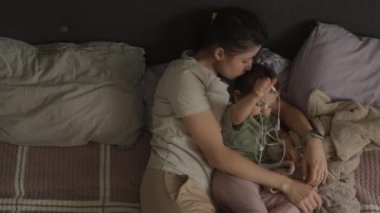 Sevimli küçük bir kız bebek emzik emiyor. Annesinin yanında yatıyor. Mutlu, neşeli bir aile. Birlikte dinleniyoruz..