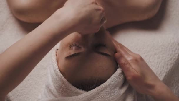 在温泉沙龙里闭眼休息的漂亮女人在温泉里做面部按摩 一个安静的女人在一个美容中心休息 专业美容院 — 图库视频影像