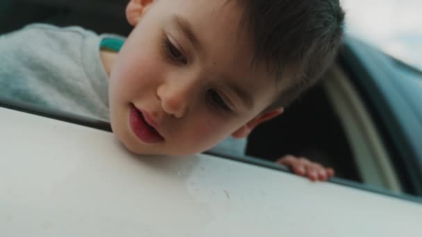 Pojke Tittar Ner Med Huvudet Sticker Bilen Genom Fönstret Lillasyster — Stockvideo