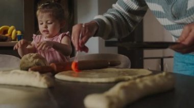 Anne ve küçük kız evcil turta hazırlıyorlar. Ev konseptinde hobilerinin tadını çıkarıyorlar. Mutlu aile günleri. Yemek hazırlama..