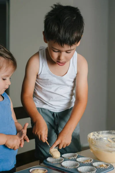 白人男孩把面团倒进厨房里的纸杯蛋糕硅胶模子里 糖果烹饪的概念 美味的食物 准备食物 — 图库照片