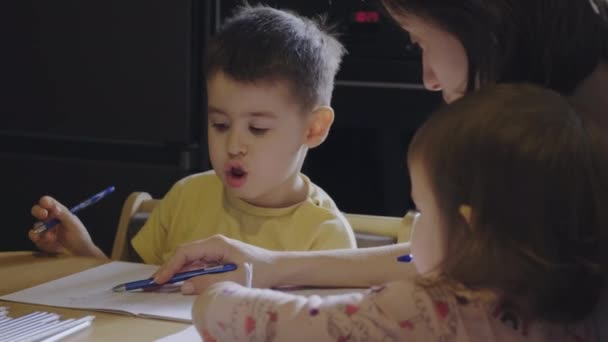 Kaukasiska Pojke Studerar Med Mamma Och Hennes Lillasyster Sitter Vid — Stockvideo