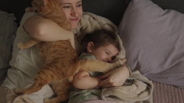 Молода Мати Своєю Донькою Відпочиває Ліжку Вранці Своїм Імбирним Котом — стокове відео