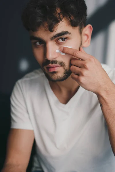 Närbild Unga Kaukasiska Mannen Titta Bort Tillämpa Fuktgivande Ansiktsbehandling Rynka — Stockfoto