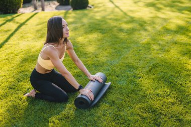 Eğitimini tamamladıktan sonra siyah spor paspası süren bir kadın. Spor aletleri, pilates, yoga. Konsept olarak....