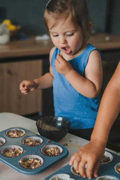 可爱的小宝宝把松饼糊放进烤杯里 在家烤的时候吃巧克力 快乐家庭孩子的概念 — 图库照片