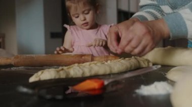Mutfakta gururlu bir büyükannesi olan mutlu bir kız bebek aile için turta pişiriyor. Mutlu aile günleri. Yemek hazırlama..