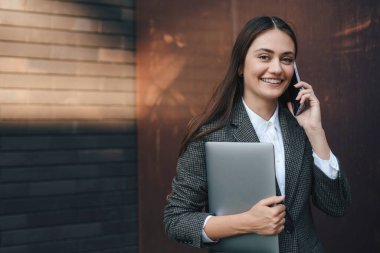 Başarılı bir iş kadınının cep telefonuyla konuşması güneşli bir günde açık havada dolaşması. Çevrimiçi iletişim. Çevrimiçi iş konuşmacısı
