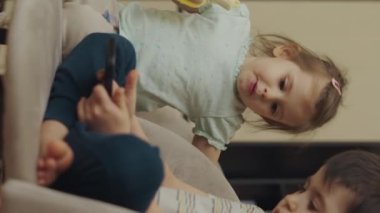 Erkek ve kız kardeşlerin evde cep telefonu kullanmaları online oyunlar oynamaları. Boş zaman aile kavramı. Cep telefonu iletişimi. Çevrimiçi oyna.