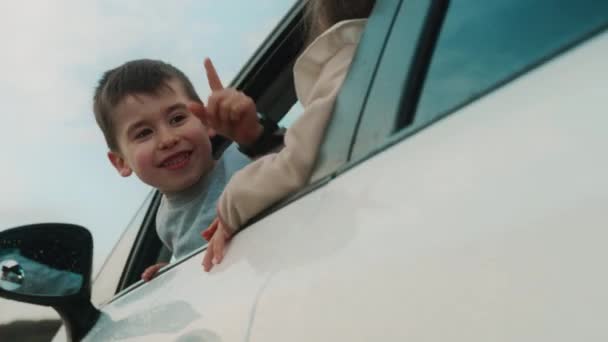 Dwoje Szczęśliwych Dzieci Wystających Głowami Przez Okno Samochodu Chłopiec Wskazujący — Wideo stockowe