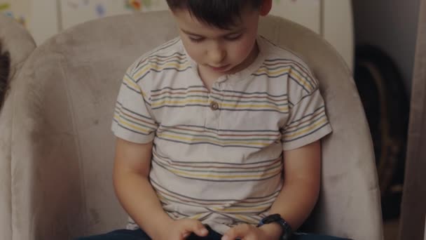 Menino Segurando Celular Mãos Sentado Sofá Casa Sozinho Jogando Jogo — Vídeo de Stock