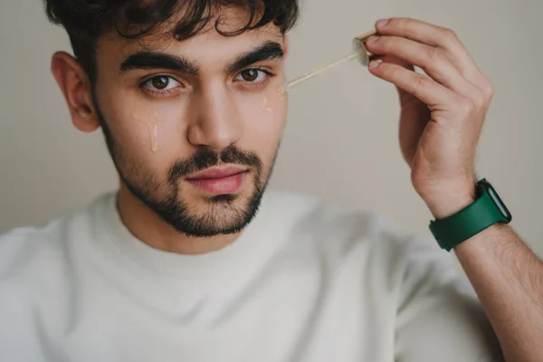 Ung Man Applicerar Organiskt Essentiellt Serum Ansiktet Med Pipett Tittar — Stockfoto