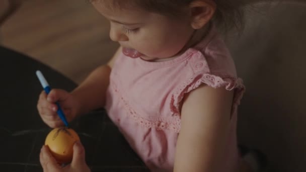 Маленькая Девочка Рисует Фигуры Яйцах Синим Маркером Праздник Сидя Столом — стоковое видео