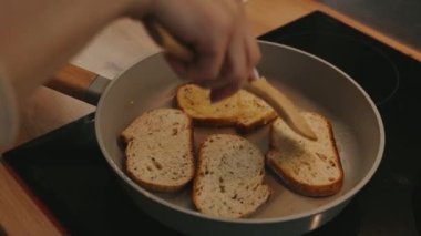 Tavada kızarmış ekmeğin üst görüntüsü, hızlı atıştırma, kahvaltı ya da öğle yemeği pişirme süreci. Kahverengi kabuklu kızarmış ekmek. Geleneksel yemek